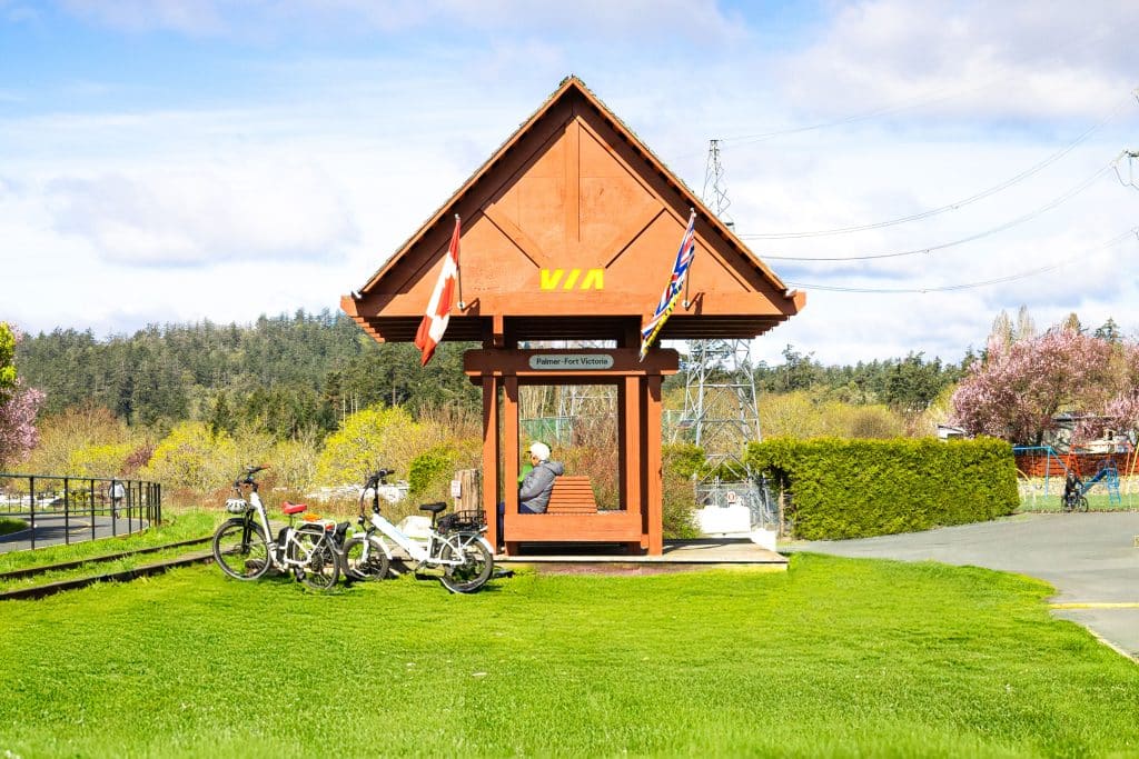 Red VIA station structure with Canadian and British Columbia flags at Fort Victoria RV Park.