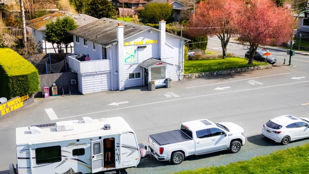 White RV parked outside the Fort Victoria RV Park office for check-in.