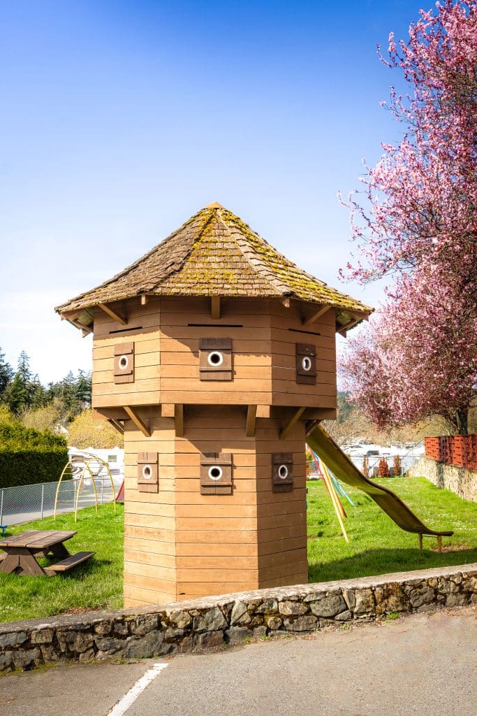 Close-up of the blockhouse tower at Fort Victoria RV Park with pink blossoms.